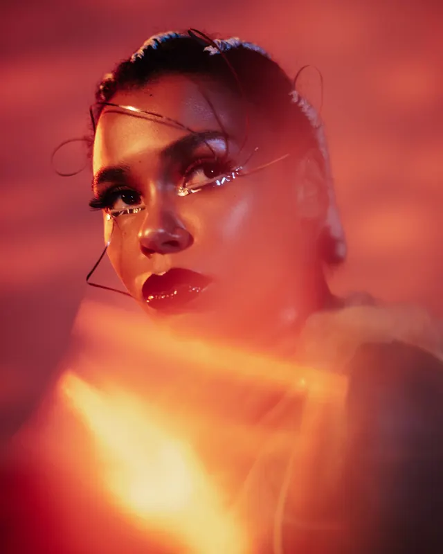 Red-lit fashion portrait with wire headpiece, editorial, photographic, warm