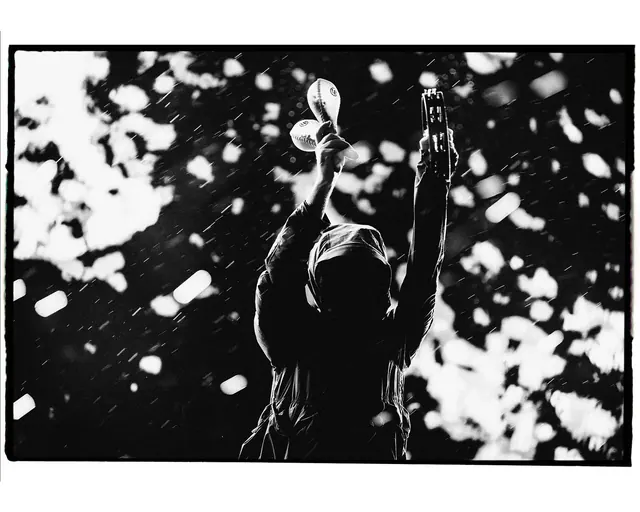 Hooded musician in rain silhouette, photographic, monochrome, monochrome