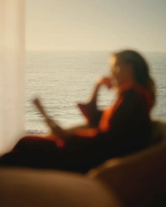 Dreamy ocean-view interior silhouette, photographic, minimal, warm