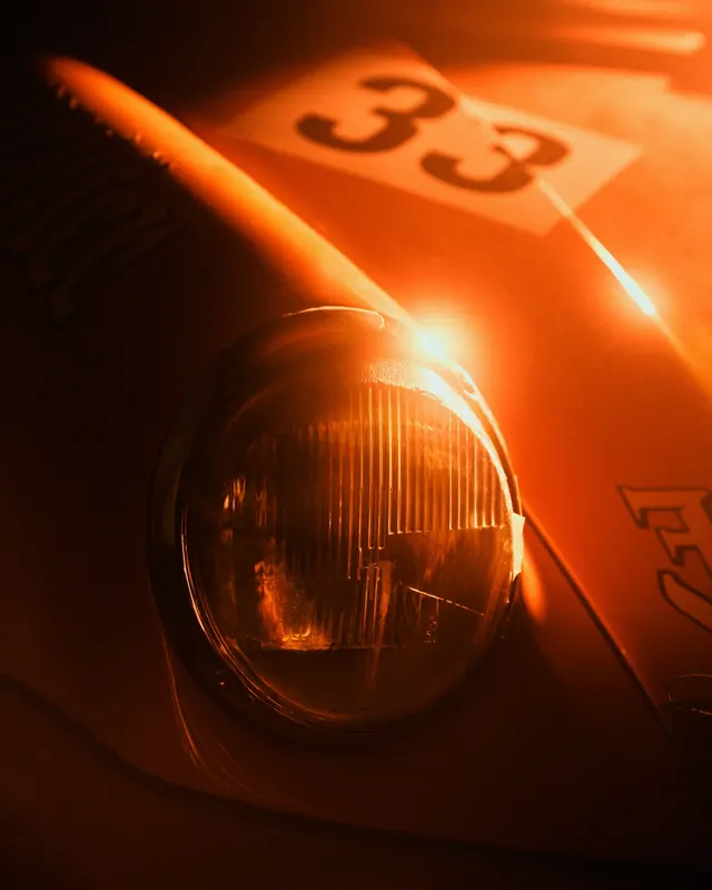 Vintage race car headlight close-up, photographic, retro, warm