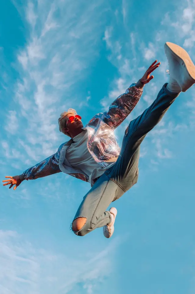 Silver sequin jacket mid-air jump portrait, photographic, playful, cool