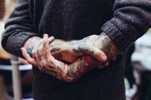 Tattooed hands gesture with warm color grading, photographic, portrait, warm