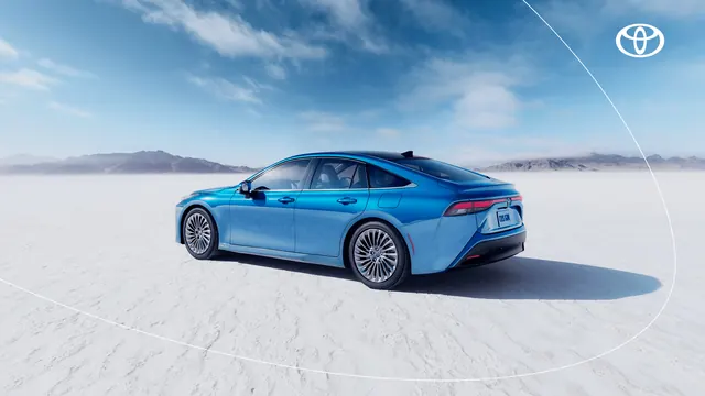 Luxury blue Toyota sedan on white salt flats with mountain backdrop, photographic, minimalist, cool