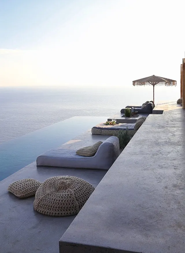 Clifftop poolside terrace at golden hour, photographic, minimal, cool