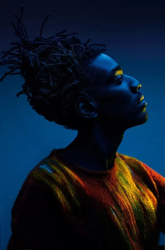 Blue portrait with textured dreadlocks and gold accents, photographic, abstract, vibrant
