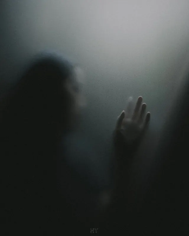 Silhouetted figure reaching through translucent fabric—moody portrait, photographic, dark-mode, dark