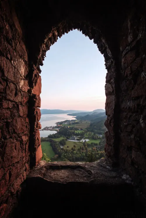 Framed landscape through stone arch, photographic, warm