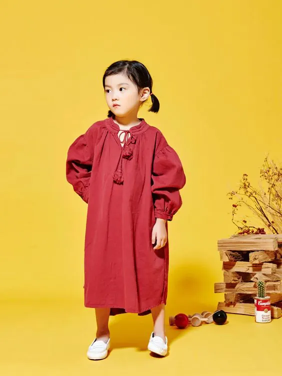 Child in red dress on golden background, flat, playful, vibrant