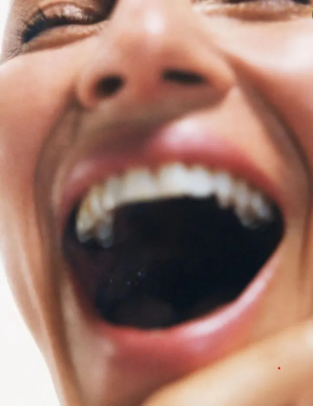 Close-up mouth smile with metallic shimmer, photographic, editorial, warm