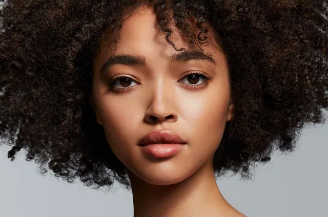 Close-up beauty portrait with curl texture, photographic, minimal, warm