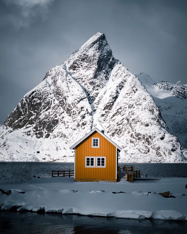 Yellow cabin in snowy mountain landscape, photographic, minimal, high-contrast