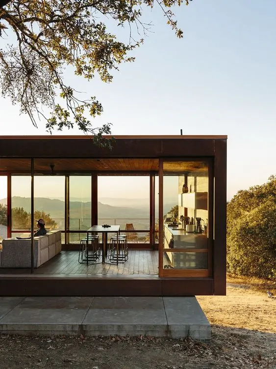Cantilevered modern glass house with landscape views, photographic, technical, warm