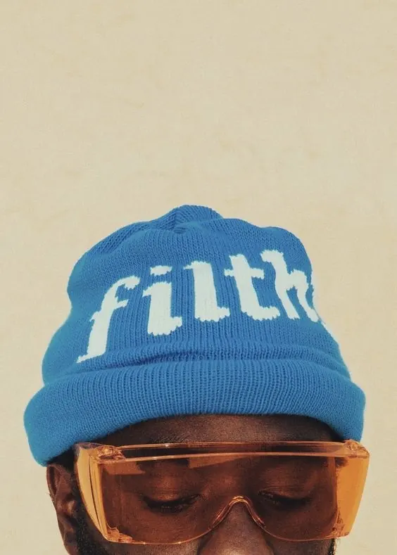 Portrait with bold blue beanie and tinted sunglasses, photographic, playful, vibrant