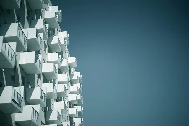 Modernist apartment building facade against teal sky, photographic, architectural, cool