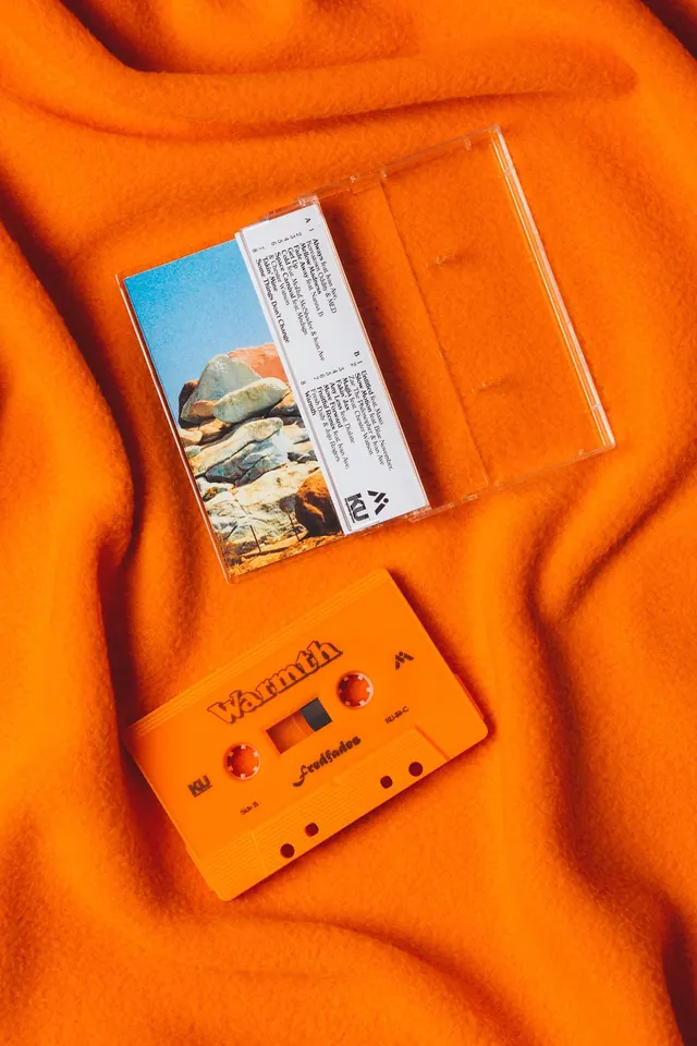 Retro cassette tape and textile flat-lay, photographic, organic, warm
