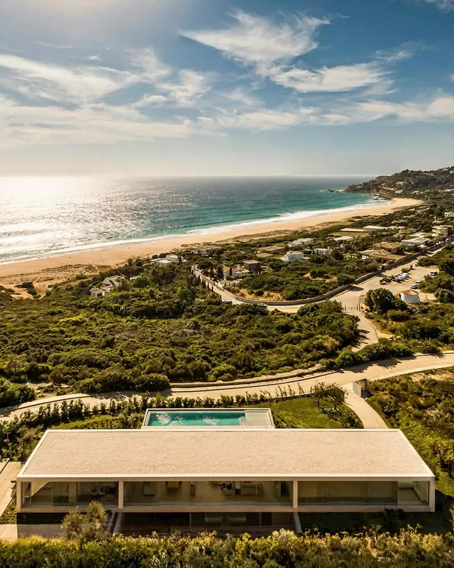Aerial resort landscape with infinity pool, photographic, minimalist, warm