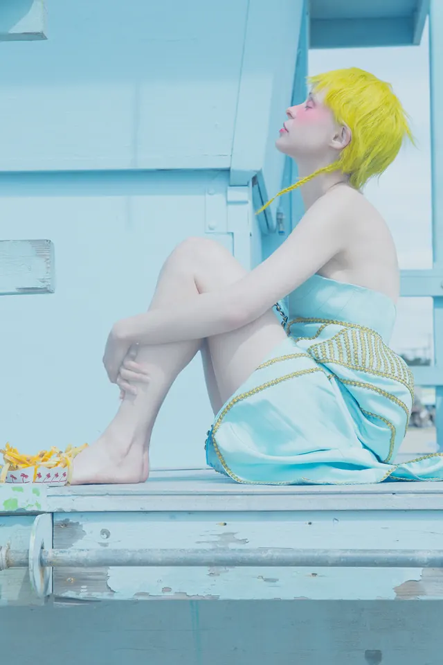 Surreal blue-toned portrait with yellow wig, photographic, surreal, cool