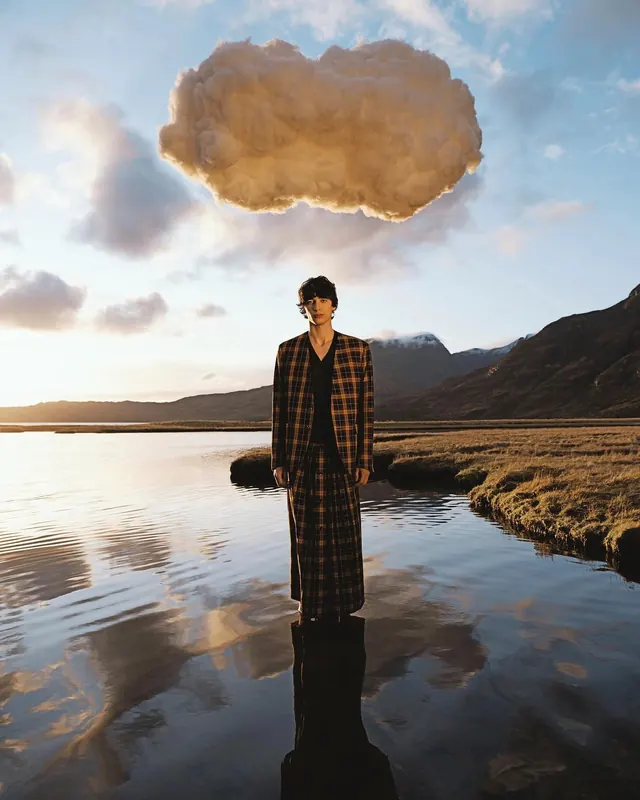 Golden hour portrait with dramatic sky and water, photographic, editorial, warm