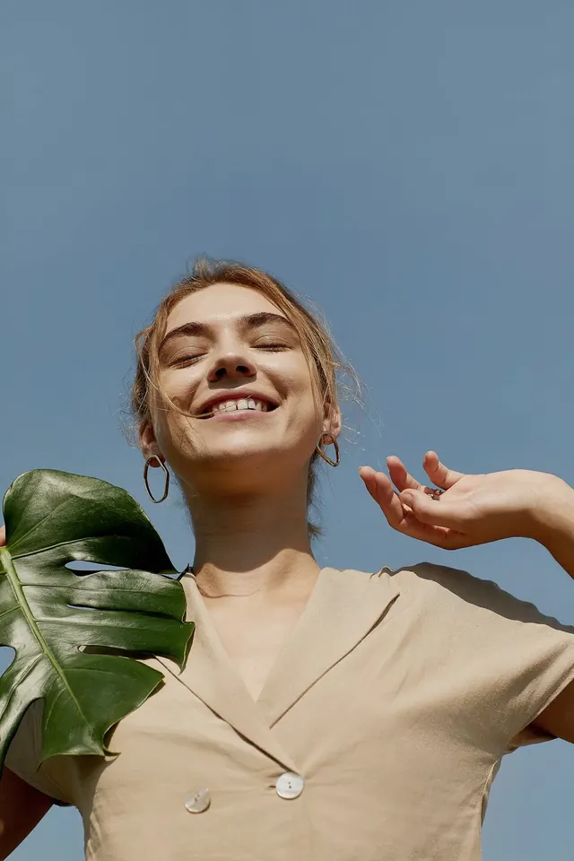 Portrait of a smiling woman with tropical leaf