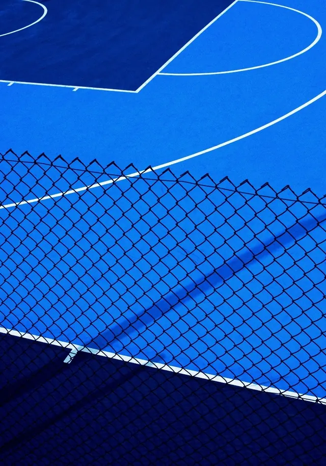 Blue court lines and chain link fence, photographic, minimal, vibrant