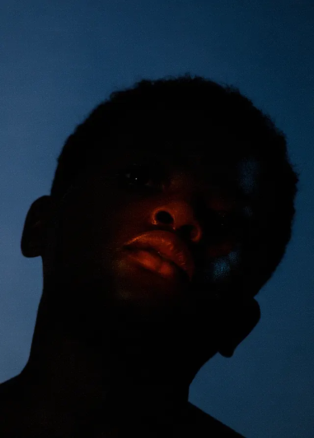 Cinematic low-key portrait with warm highlights, photographic, dark-mode, dark