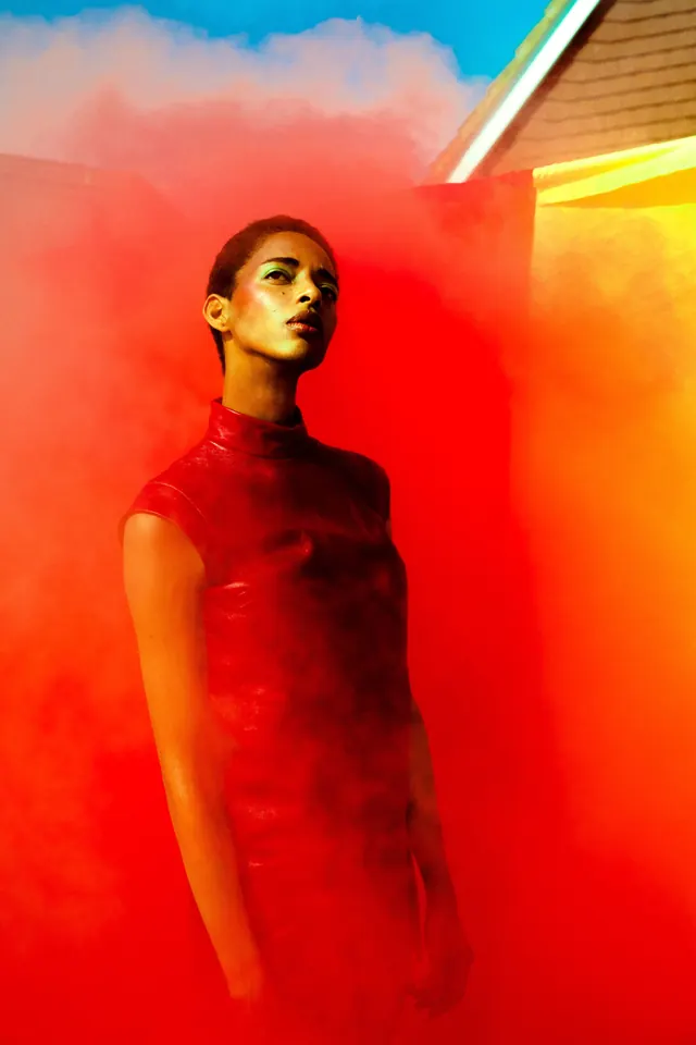 Red leather dress fashion portrait in smoke, editorial, photographic, vibrant
