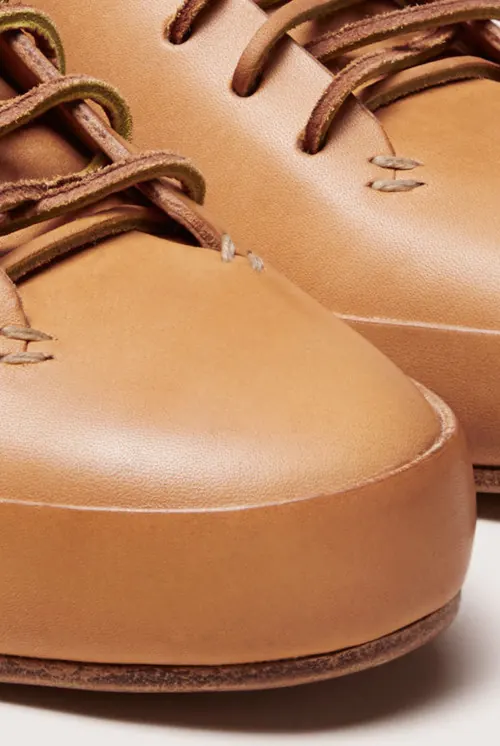Tan leather lace-up shoes close-up, minimal, photographic, warm