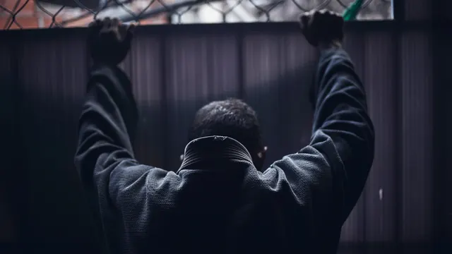 Person with Raised Arms in Dark Setting