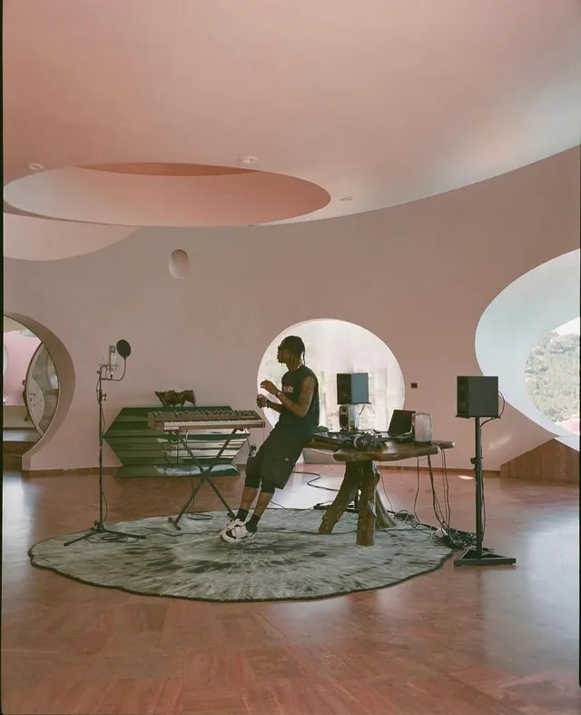 Musician in pink curved studio, photographic, organic, warm