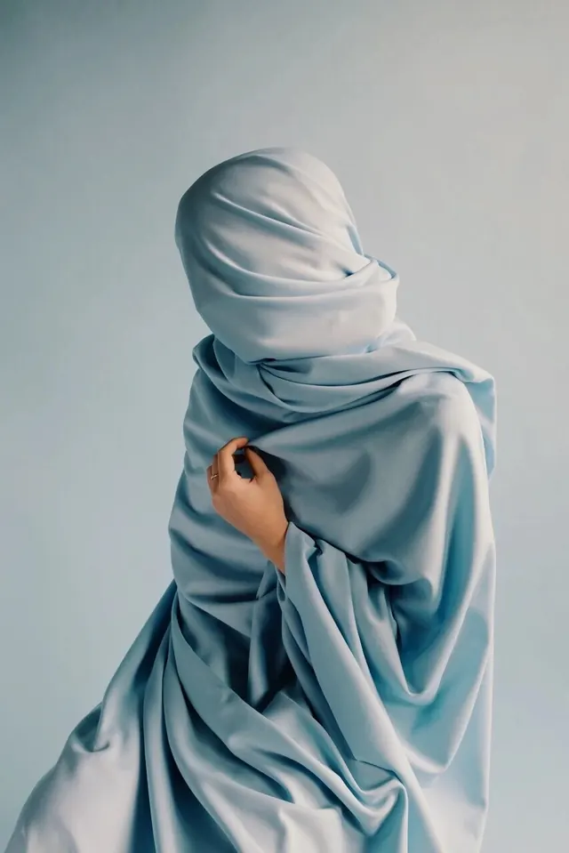 Veiled Figure in Blue Fabric