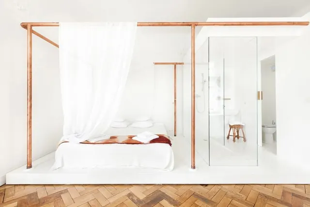 Minimalist hotel suite with copper bed frame, minimal, light-mode, light