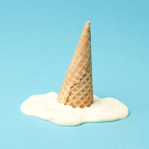 Melting ice cream cone on blue, minimal, photographic, light