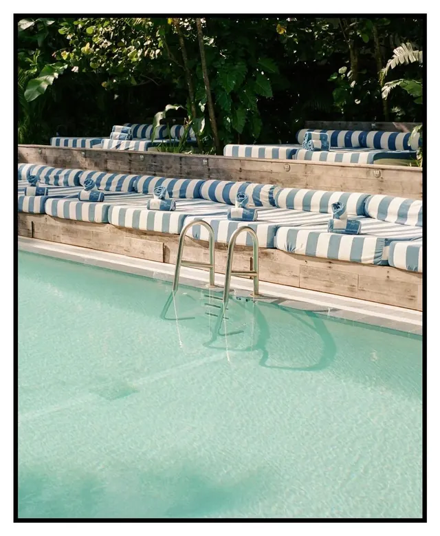 Striped sunbed poolside scene, photographic, editorial, vibrant