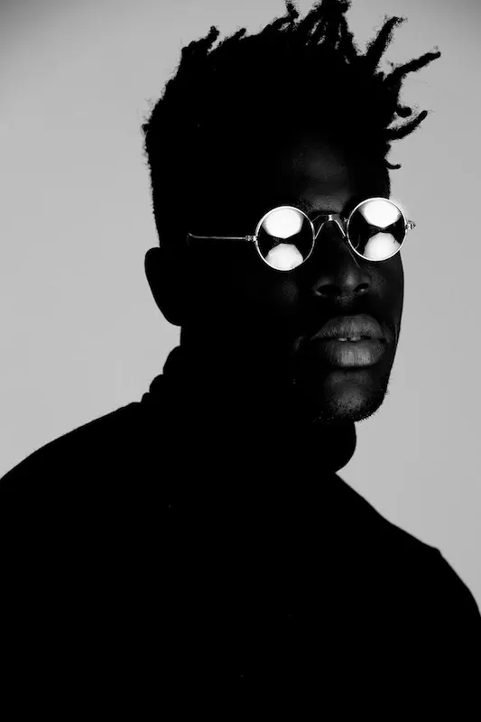 Portrait with round mirrored sunglasses, photographic, minimalist, monochrome