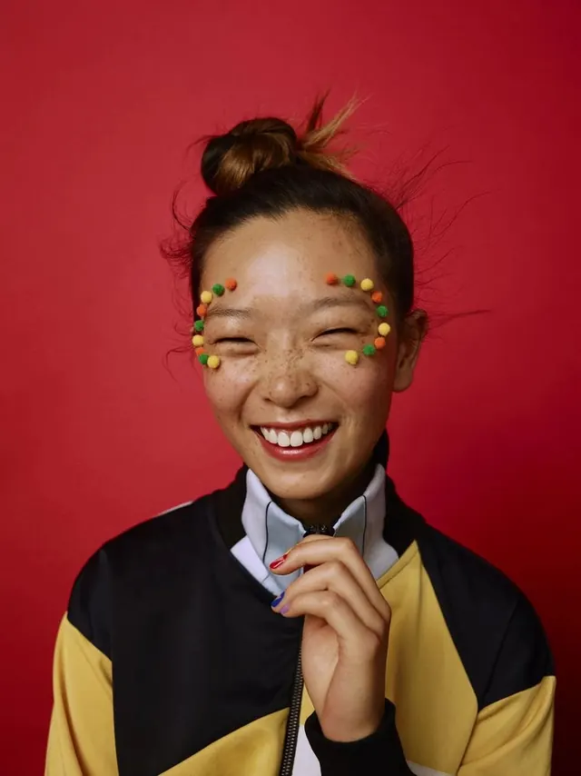 Portrait with colorful face paint accents, photographic, playful, dark