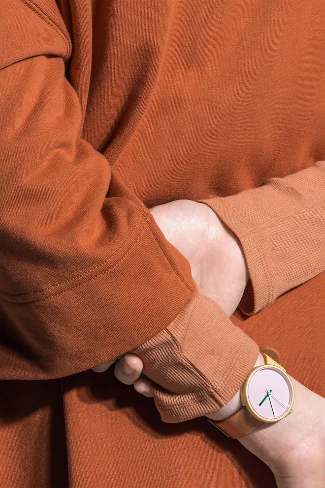 Product fashion shot with terracotta-toned fabric and watch, photographic, minimal, warm