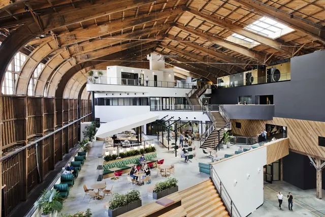Modern office in historic industrial hangar, photographic, technical, warm