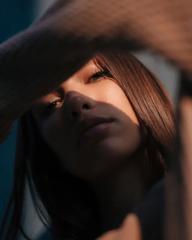 Contemplative portrait with dramatic lighting, photographic, editorial, dark