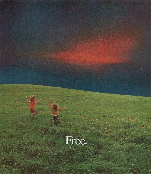 Free" text over pastoral landscape, photographic, minimal, warm