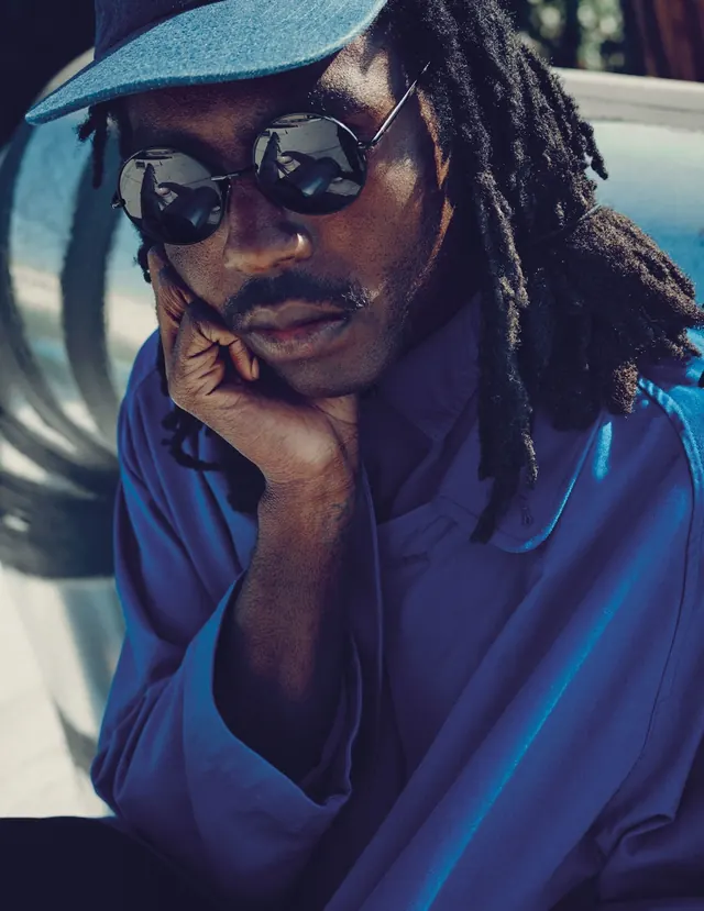 Portrait with blue light glow and aviator sunglasses, photographic, editorial, cool