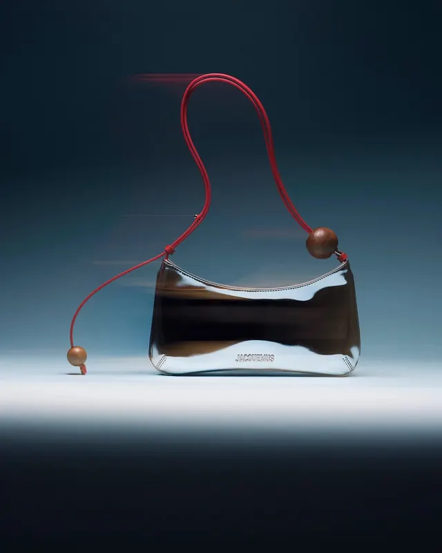 Luxury handbag with red cord detail on gradient background, luxury, minimal, dark