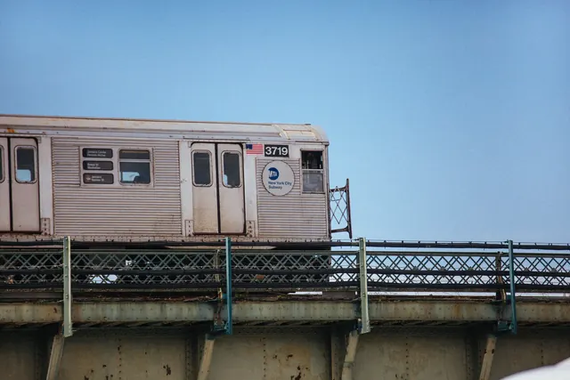 NYC subway train on elevated bridge, photographic, technical, cool