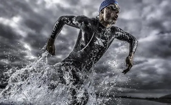 Athlete running through water splash, photographic, technical, dark