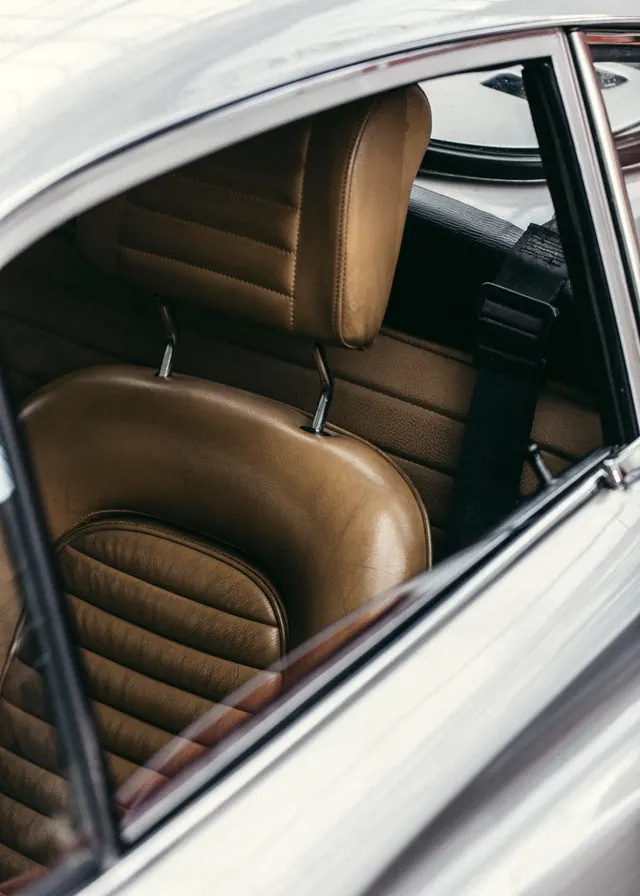 Vintage car interior with tan leather seats, photographic, warm