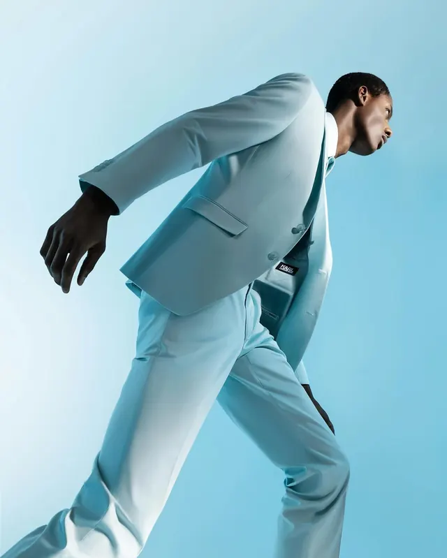 Figure in light blue suit against blue background, photographic, editorial, cool