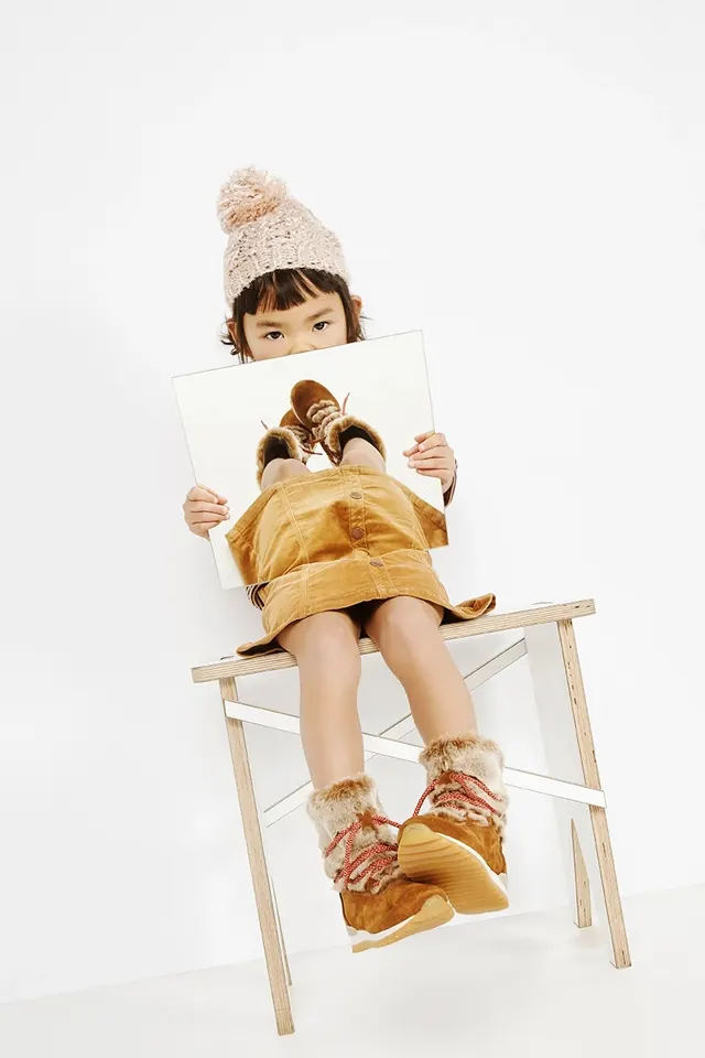 Child with portrait in golden outfit, photographic, light-mode, warm