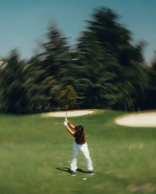 Golfer mid-swing on fairway, photographic, technical, cool
