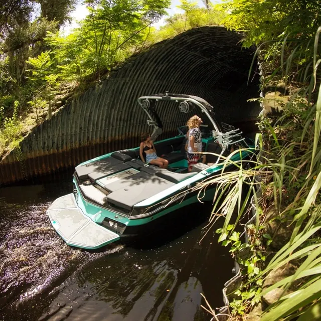 Green motorboat on river, photographic, organic, vibrant