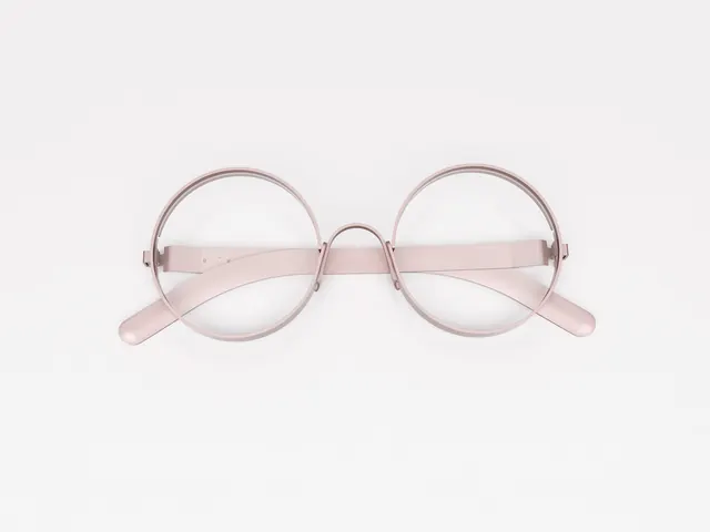 Round eyeglasses on light background, minimal, photographic, light