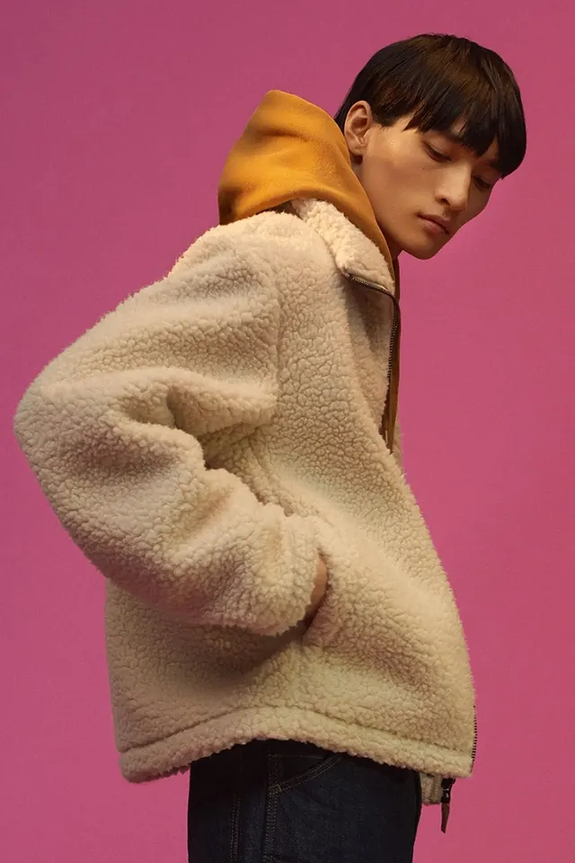 Oversized fleece jacket and textured knitwear on figure, playful, editorial, vibrant